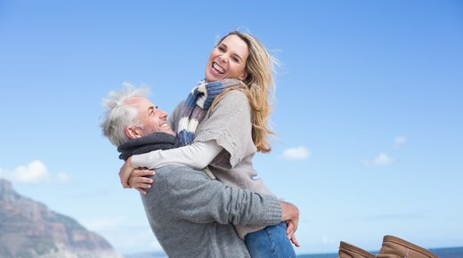 Mann hebt Frau am Strand hoch
