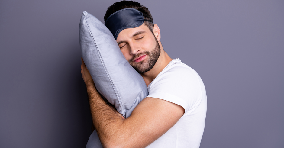 Mann mit Schlafmaske und Kissen