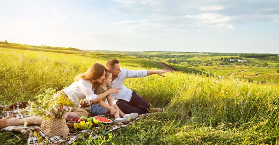 Mann, Frau und Kind beim Picknick in der Wiese