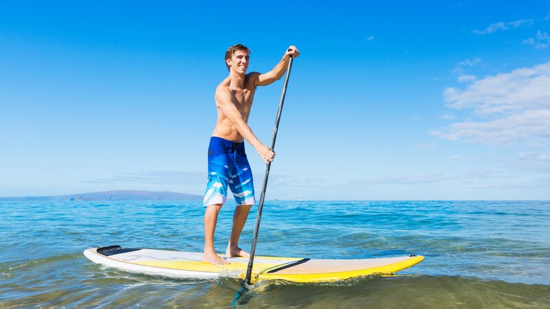 Junger Mann auf einem Stand-up-Paddleboard