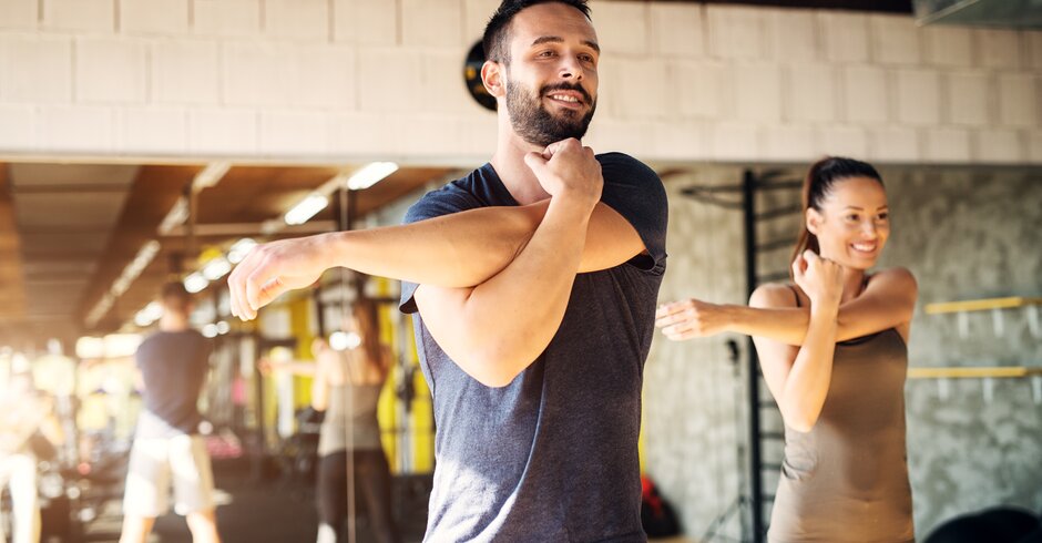 Frau und Mann beim Stretching im Fitnessstudio