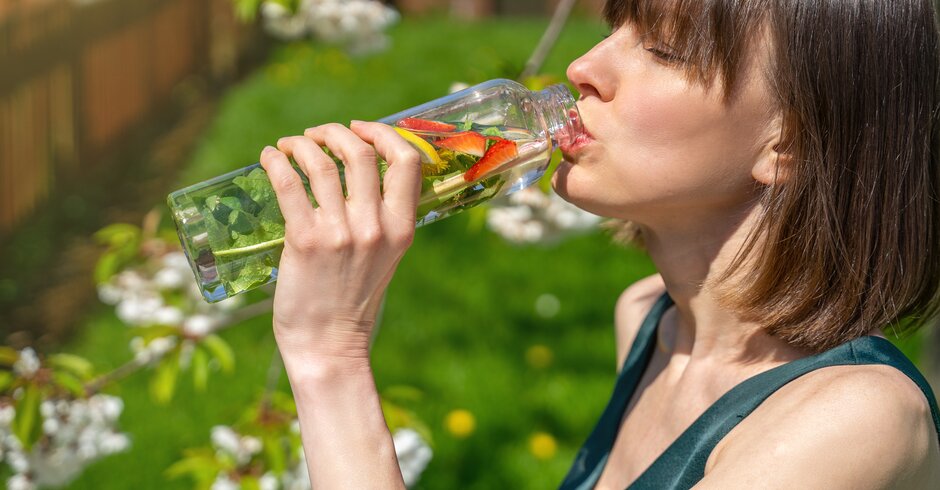 Frau trinkt bei Hitze aus ihrer Wasserflasche