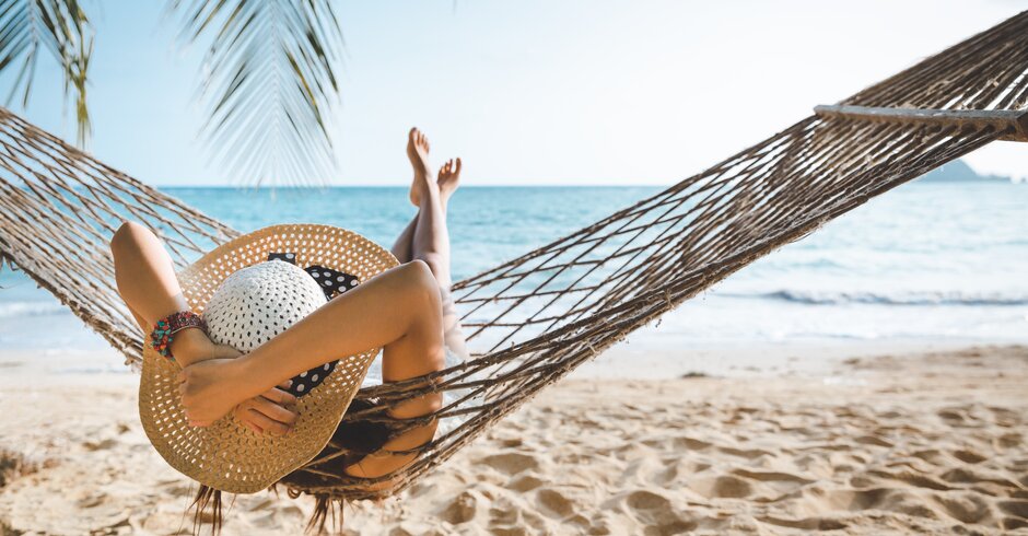Frau liegt in einer Hängematte am Strand