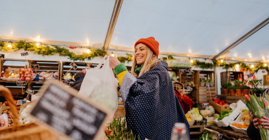 Frau kauft Lebensmittel auf dem Wochenmarkt ein